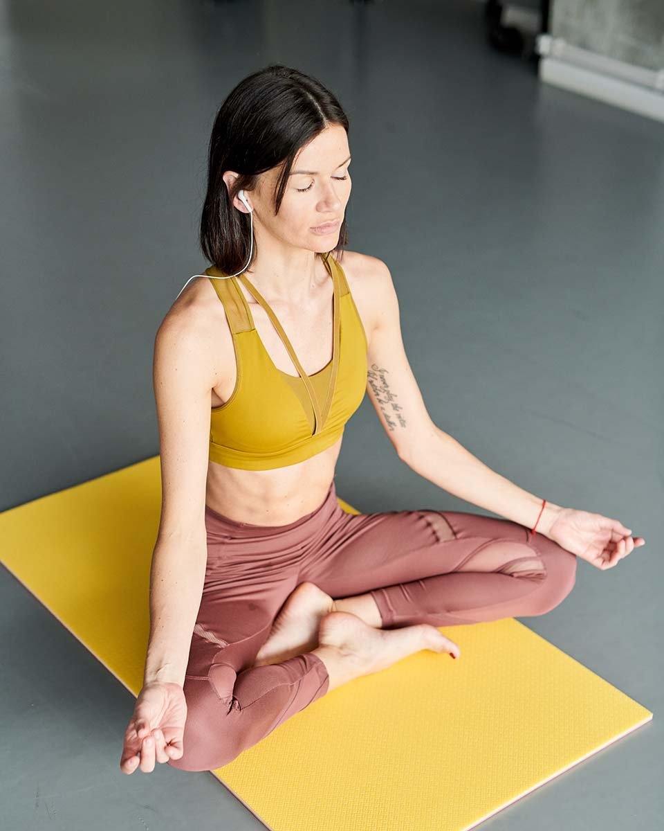 young-woman-meditating-in-gym-QGFPS6X.jpg